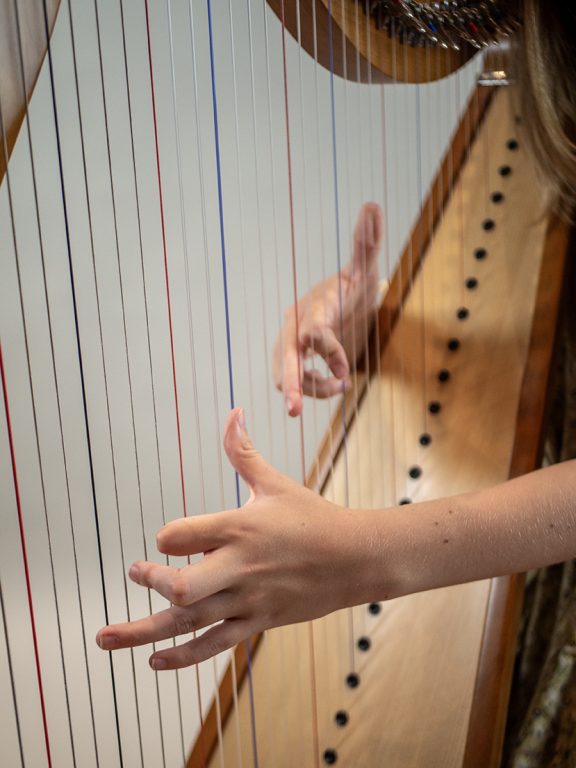 close-up van harp met handen in kleur