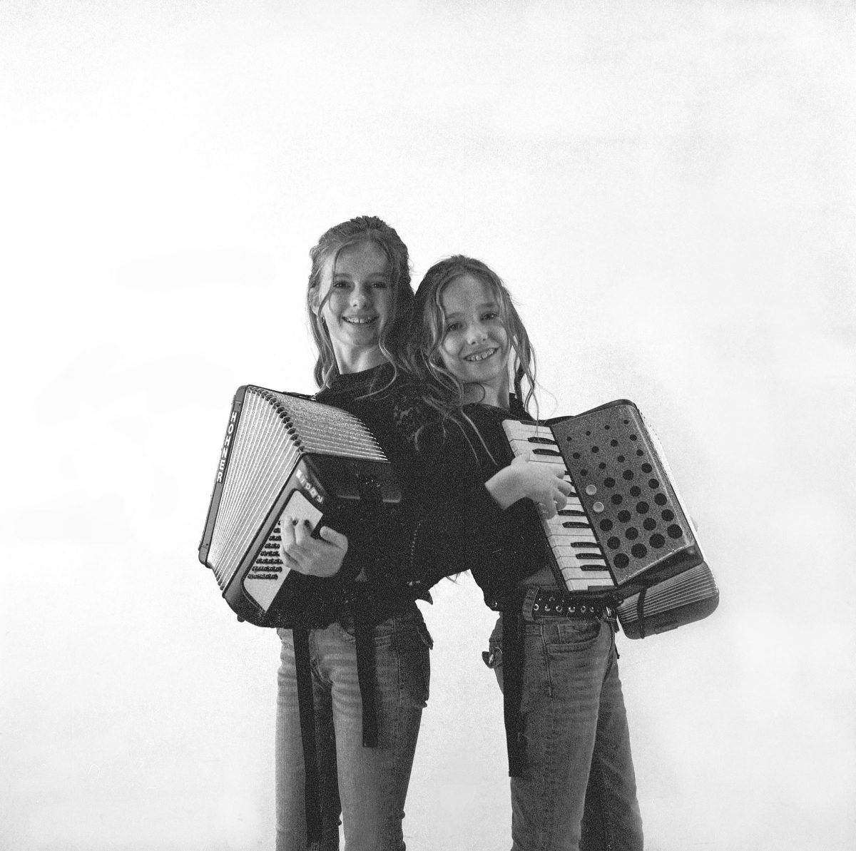 twee meisjes met ieder een accordeon in hun handen.