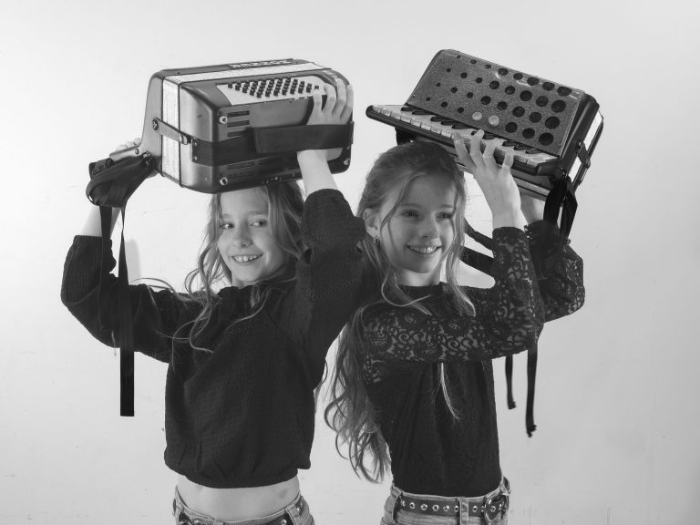 2 meisjes met ieder een accordeon op het hoofd