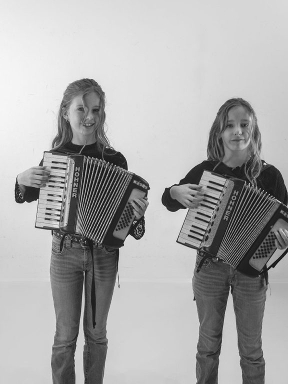twee meisjes die beide een accordeon vast houden