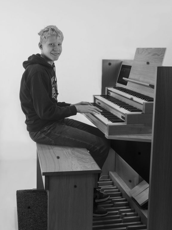 Zwart-Wit foto van jongen poserend en spelend op orgel