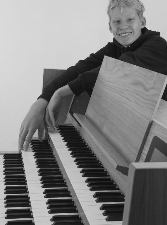 close up zwart-wit foto van jongen bij orgel